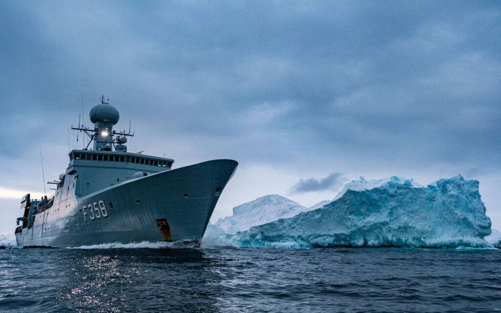 The Royal Danish Navy frigate HDMS Triton passes an iceberg in the waters around Greenland. (Image: NATO)